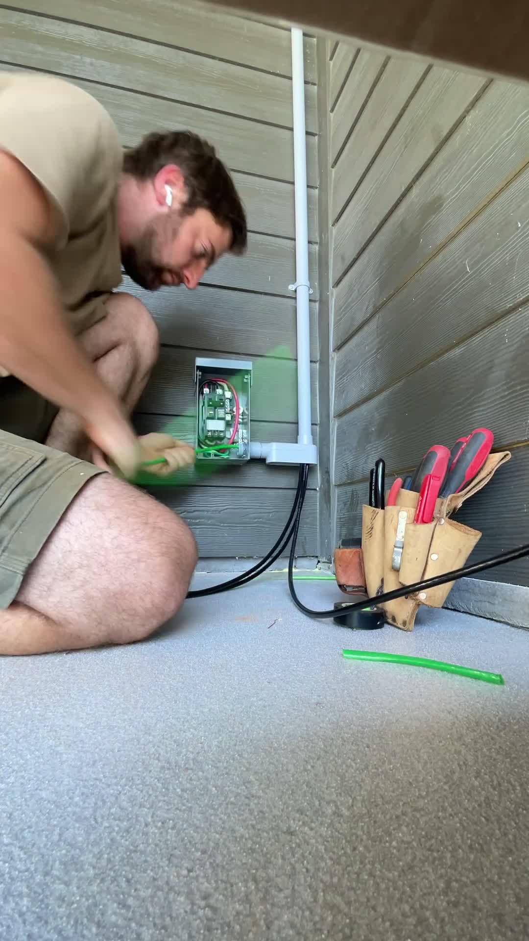 Joe Holder of Sunset Electric pulling wire for an exterior receptacle