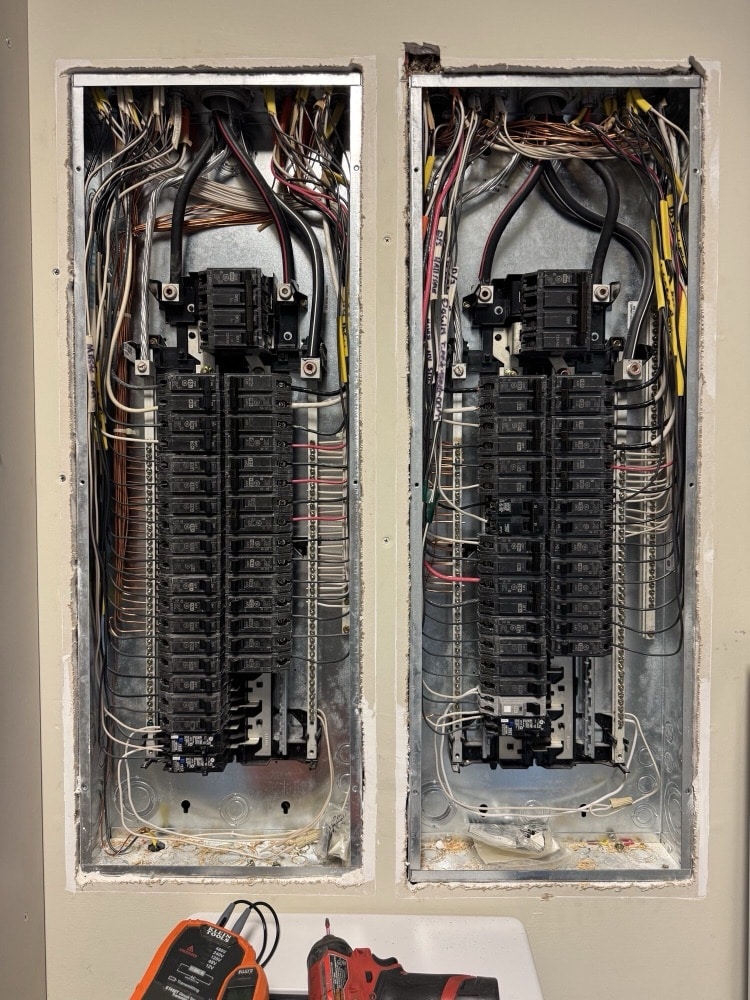 Two 200 amp breaker panels with covers off, breakers and neutral bars landed cleanly